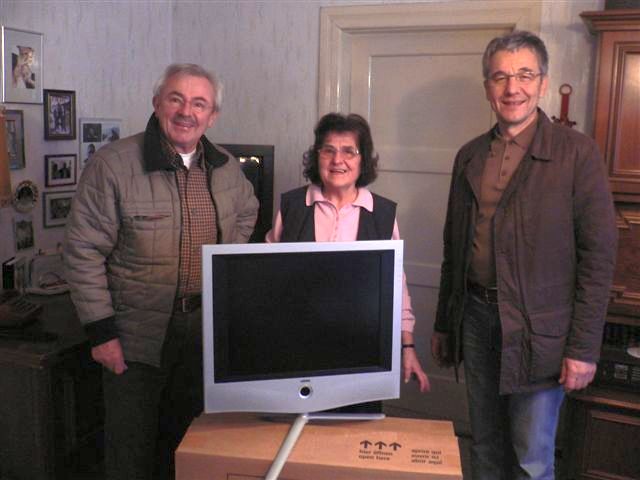 Vorsitzender M. Raum, die Gewinnerin des neuen Fernsehers und Dr. Blinzler