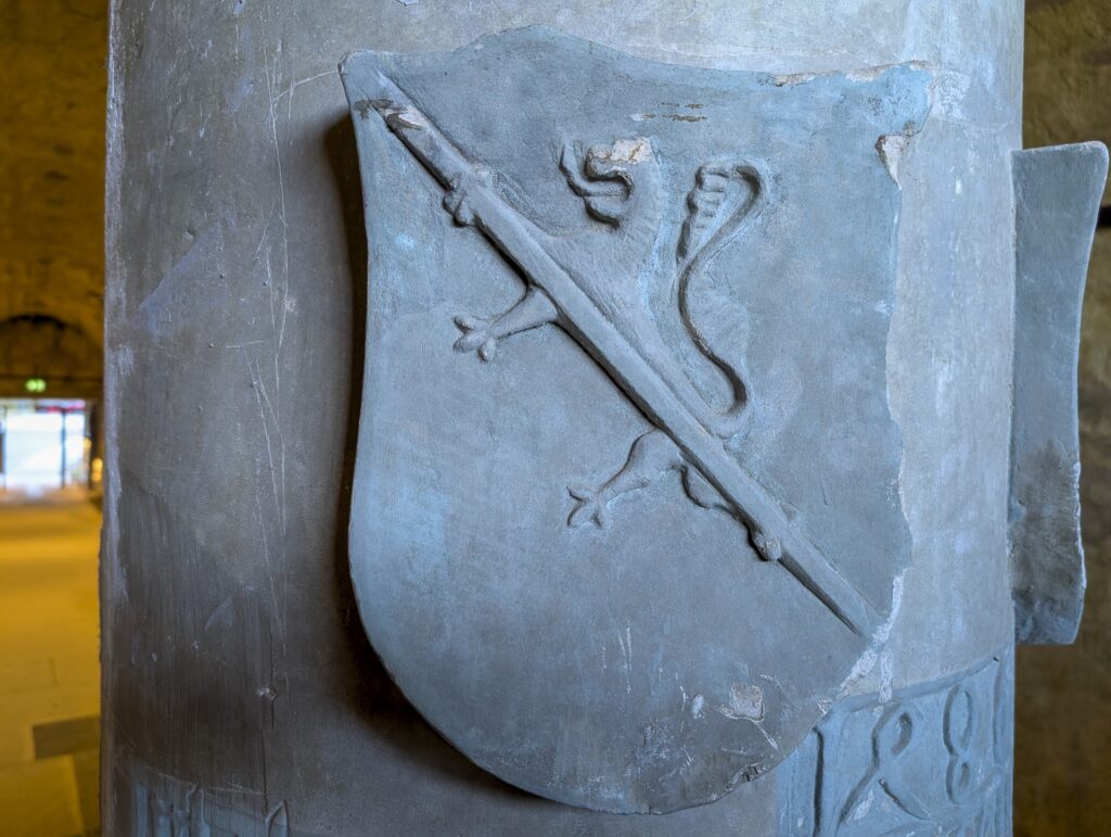 Wappenschild mit schreitendem Löwen und Schrägleiste, beschädigt